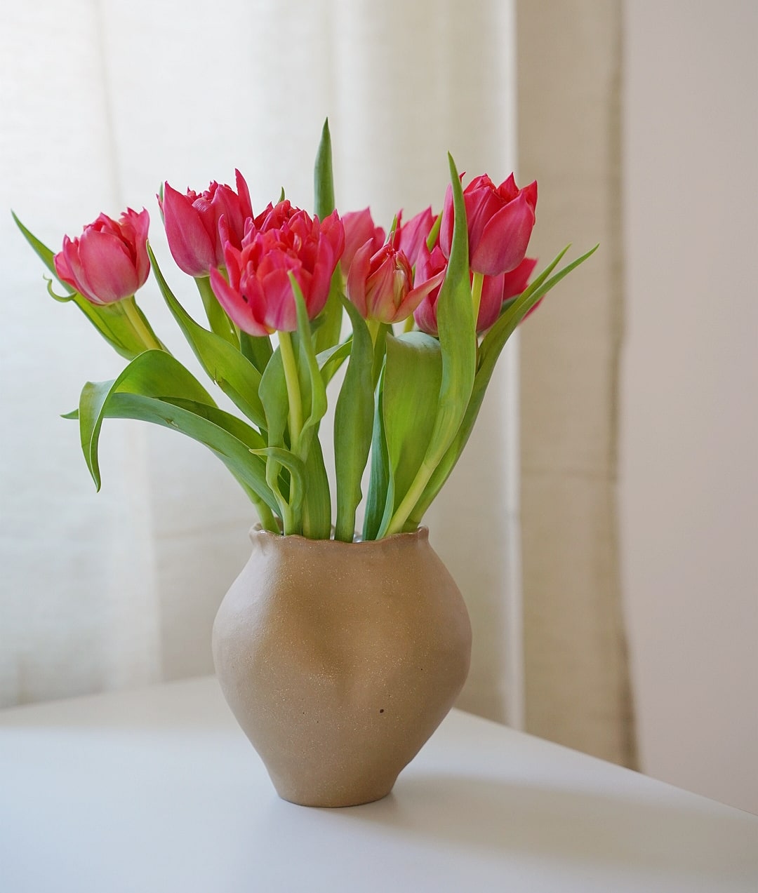 Tulpen in organisch geformter Vase aus hellbraunem Steinzeug Ton 